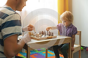 Brain games - father teaches to play chess for his child