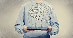 Brain illustration with man holding a tablet
