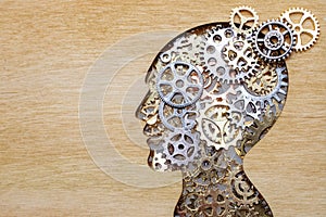 Brain model concept made from gears and cogwheels on wooden background