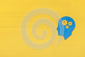 Brain works concept. Thinking, creativity concept of the human head with gears on yellow background