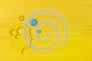 Brain works concept. Thinking, creativity concept of the human head with gears on yellow background