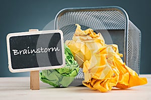 BRAINSTORM word and crumple paper spilling out from bin