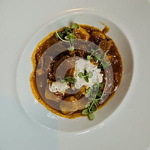 Braised beef and gnocchi with a dollop of cream photo
