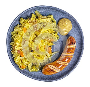 Braised cabbage with wiener and mustard on plate above, isolated