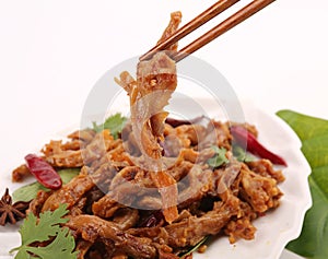 Braised duck in a white dish served with sauce