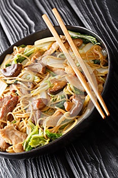 Braised Glass Noodles with Pork & Napa is a traditional Chinese dish close-up in a plate. vertical