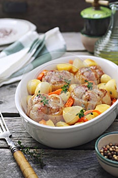 Braised meat paupiettes with potatoes and bell pepper in ceramic bakeware