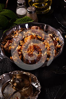 Braising meat with Italian herbs in a metal plate