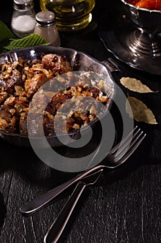 Braising meat with Italian herbs in a metal plate photo