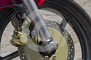 Brake disc on motorcycle front wheel together with device