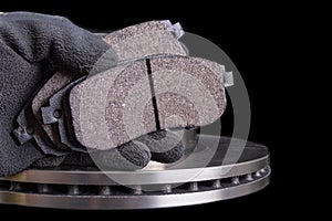 Brake pad for a passenger car in the hand of a mechanic. New spare parts for car repairs