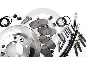 Brake parts on white: brake pads, disc, brake hose, guides, cylinders