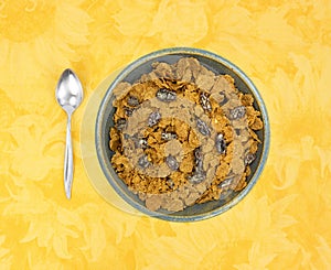 Bran flake cereal with raisins in a stoneware bowl