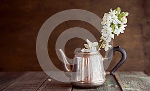 A branch of an apple tree in an iron kettle on a crowning background. With copy space.
