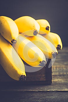 Branch of bananas on the rustic background