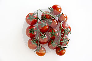 Branch of beautiful juicy organic red cherry tomatoes on white background.