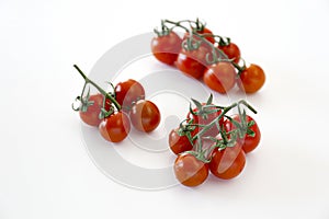 Branch of beautiful juicy organic red cherry tomatoes on white background.