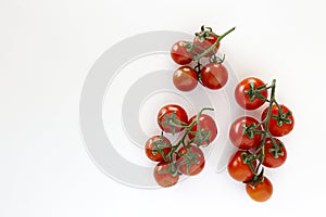 Branch of beautiful juicy organic red cherry tomatoes on white background.