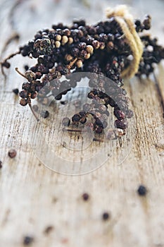 Branch of black pepper dry on wood table.