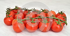 Branch of cherry tomatoes on the marble table texture