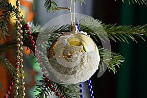 Branch of Christmas tree decorated with a Golden snow globe.