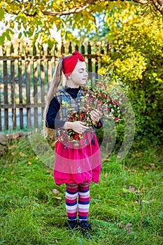 A branch of hawthorn in the hands of a cute girl in the garden.