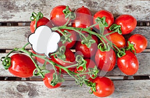 Branch of red ripe cherry tomatoes and label