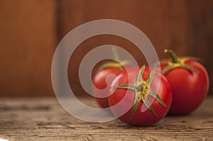 Branch of tomatoes on a dark wood background