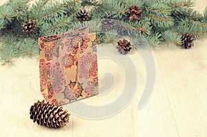 Branches of blue spruce, cones and paper shopping gift bag