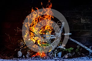 Branches are burning inside fireplace to heat it