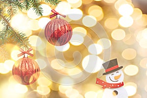 The branches of the Christmas tree are decorated with red balls on a golden background.