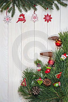 Branches of a Christmas tree, New Year`s decor on a light wooden background. Close-up, vertical shot. Design for postcards.