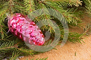 The branches of Christmas trees and fallal cone decorations on the background of wooden boards.