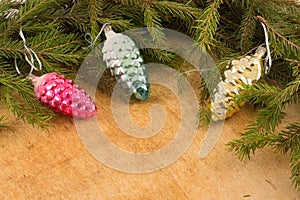 The branches of Christmas trees and fallal cone decorations on the background of wooden boards.