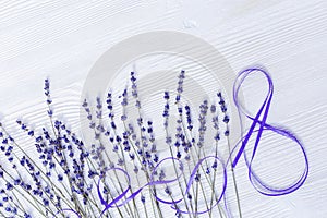 Branches of lavender and number 8 from ribbon on white wood. March 8 International Womens Day