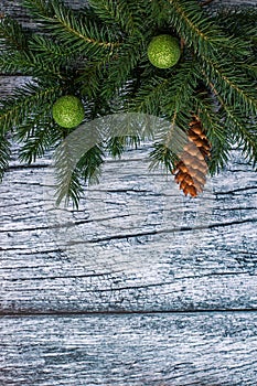 Branches of spruce with Christmas decorations on a background of old wooden panels