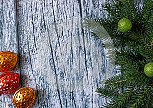 Branches of spruce with Christmas decorations on a background of old wooden panels