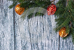 Branches of spruce with Christmas decorations on a background of old wooden panels