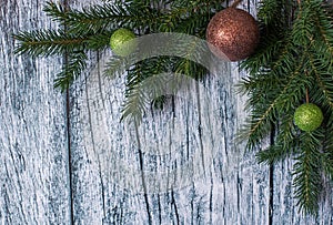Branches of spruce with Christmas decorations on a background of old wooden panels