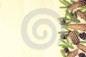 Branches of spruce and fir cones on a wooden background