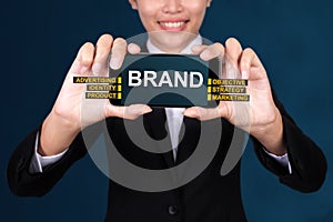 BRAND concept, Happy businesswoman Show text brand on Smart Phone photo