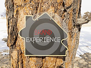 Brand experience symbol. Concept words Brand experience on beautiful black house blackboard. Beautiful tree background. Business