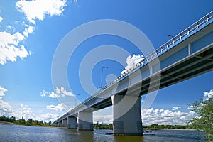 Brand new bridge over wide river under blue clear sky