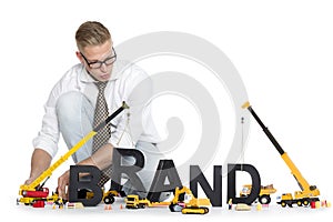 Brand start up: Businessman building brand-word.