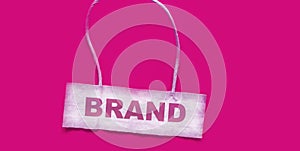 Brand, text on business card and pink background.