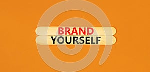 Brand yourself symbol. Concept words Brand yourself on beautiful wooden stick. Beautiful orange table orange background. Business