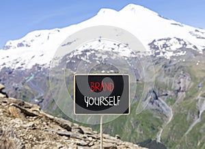 Brand yourself symbol. Concept words Brand yourself on beautiful black blackboard. Beautiful mountain Elbrus sky background.