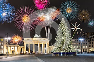Brandenburg Gate in Berlin, with fireworks and Christmas tree
