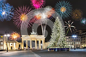 Brandenburg Gate in Berlin, with fireworks and Christmas tree photo