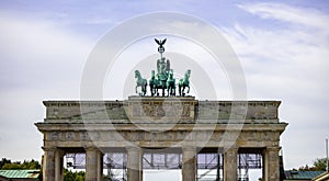 Brandenburg Gate In Berlin. Historic symbol in Germany. Cloudy sky background.